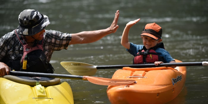 two kayakers in a class giving high fives