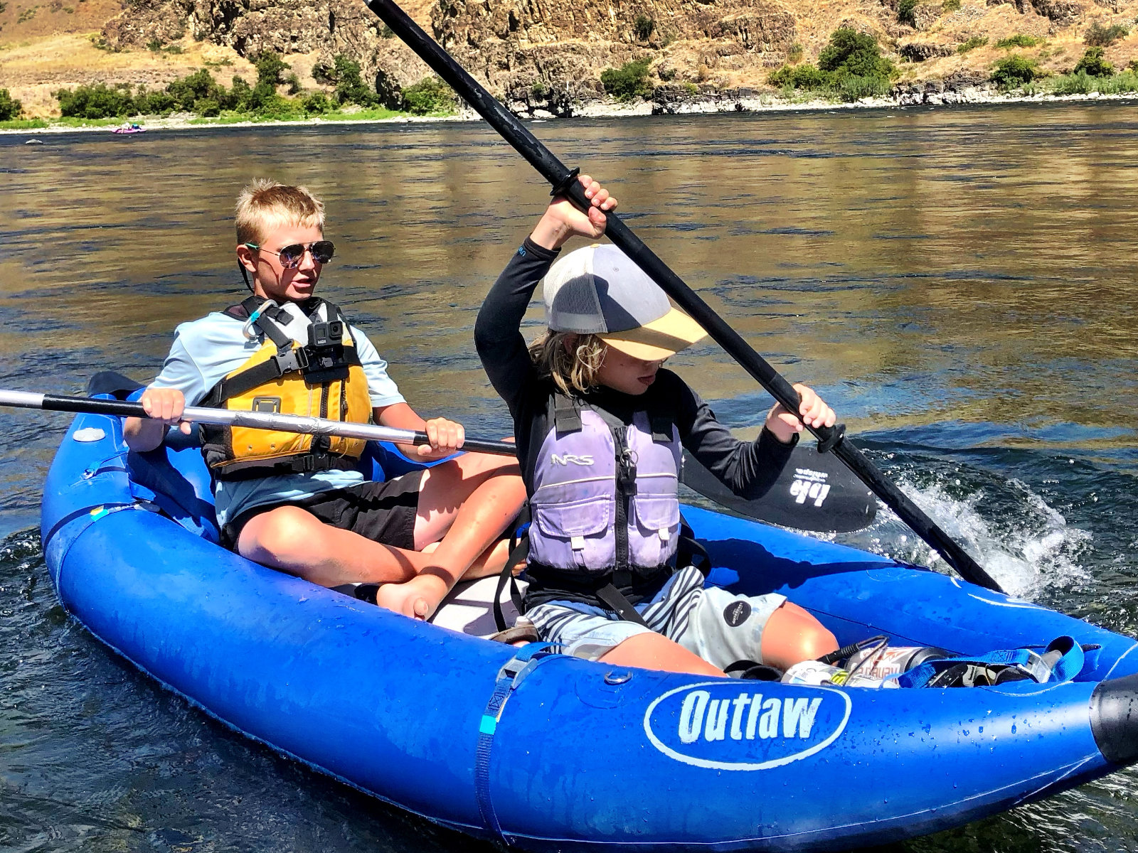 family-camp-kids-paddling-inflateable-kayak