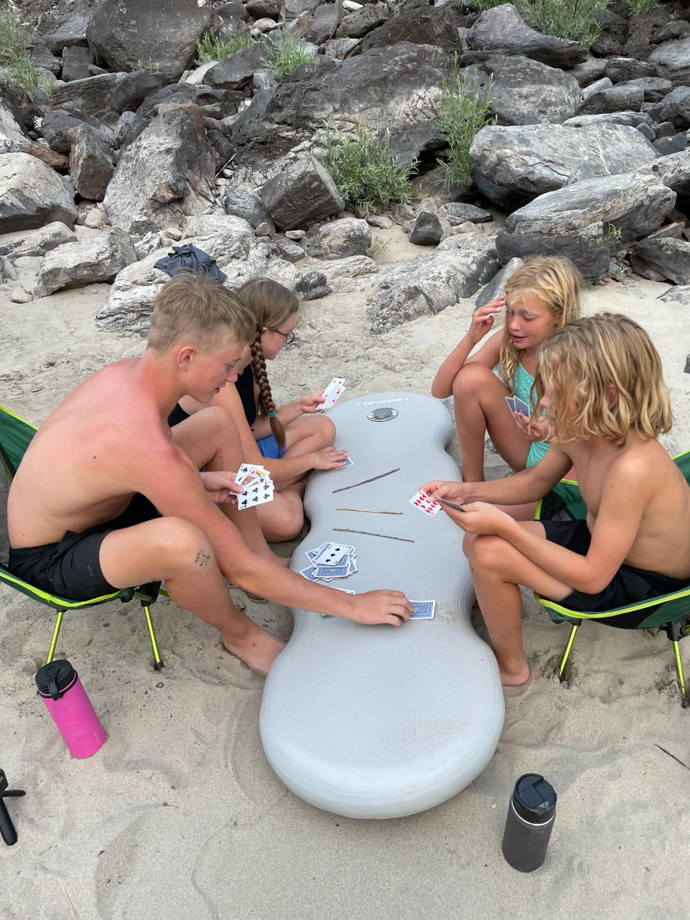 family-camp-kids-playong-cards-on-beach