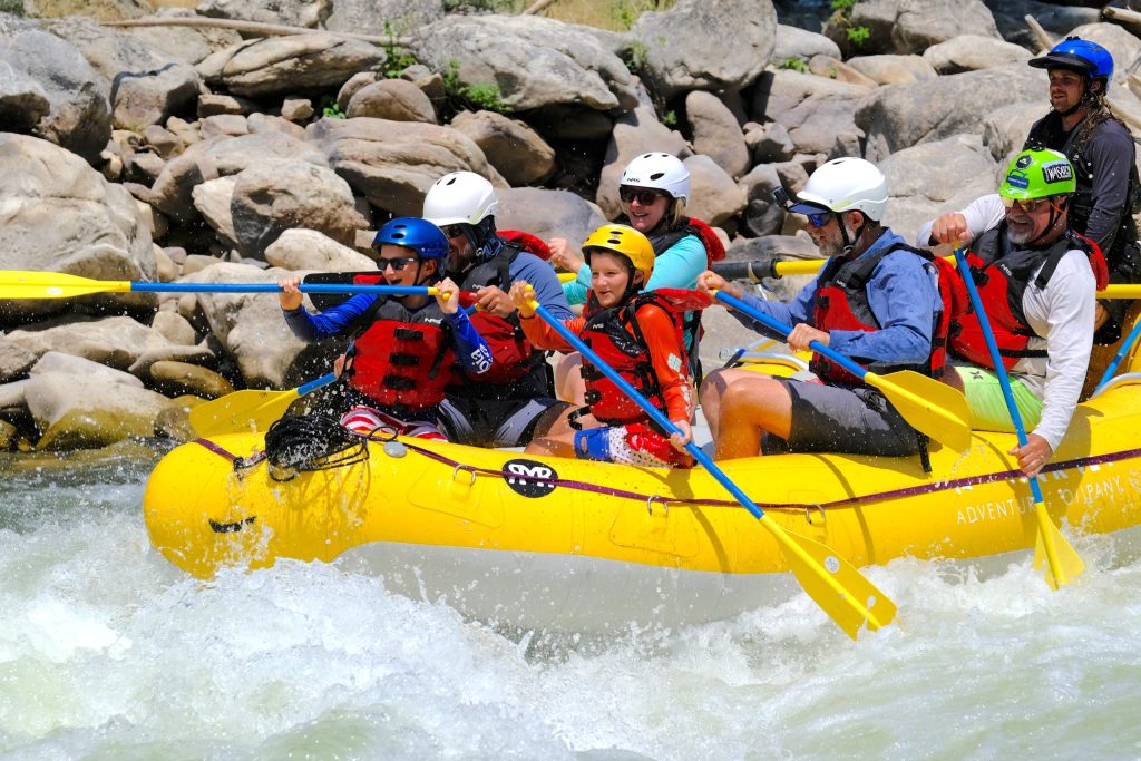 Rafting group working together in a fast-moving rapid.