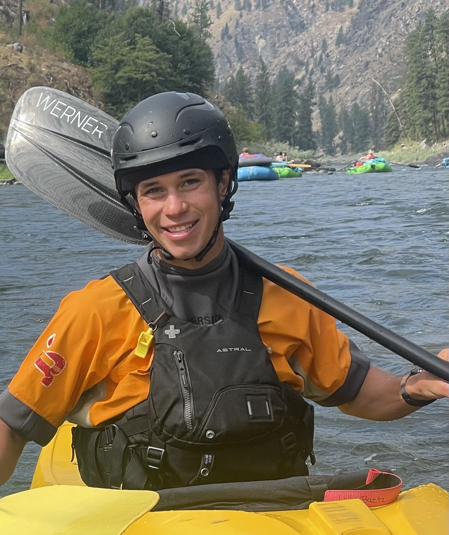 Experienced kayaking guide posing with a paddle and life jacket.